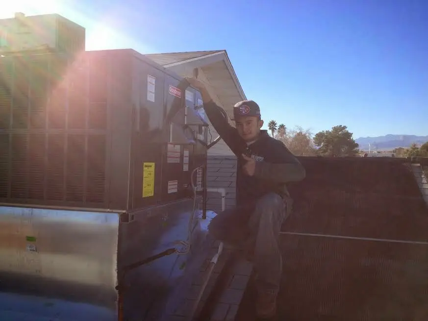 HVAC technician performing AC Tune-Up on a rooftop unit in Rio Rico